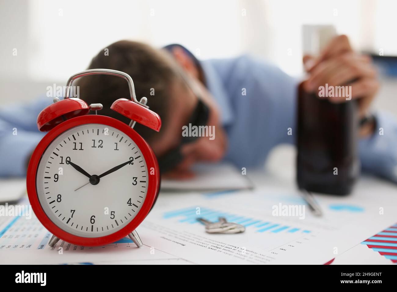 Red vintage clock show time, drunk man fell asleep on workplace in office Stock Photo