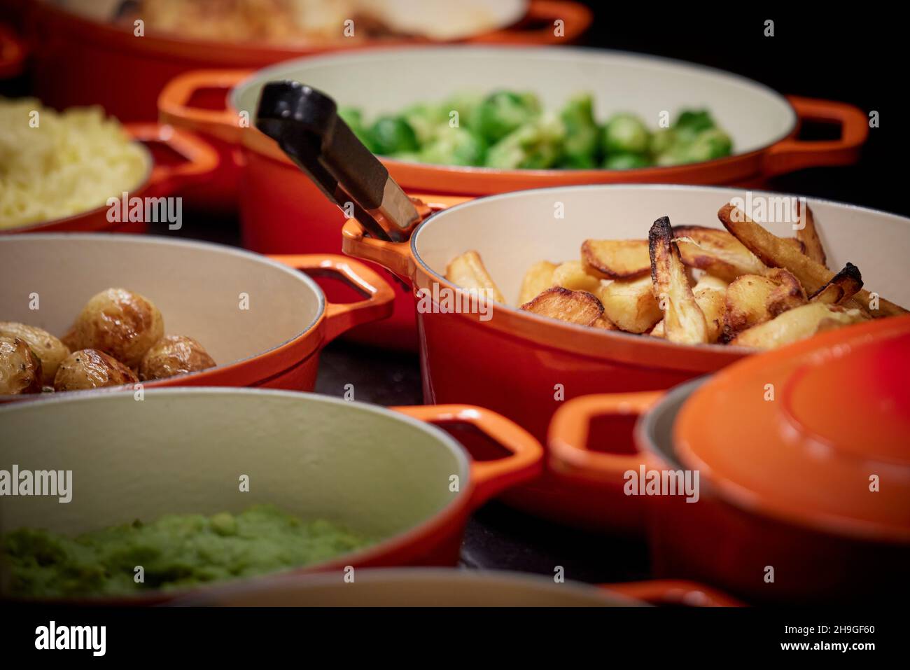 Pub carvery self service cooking pots, roasted potatoes, parsnips, Brussel spouts, Stock Photo