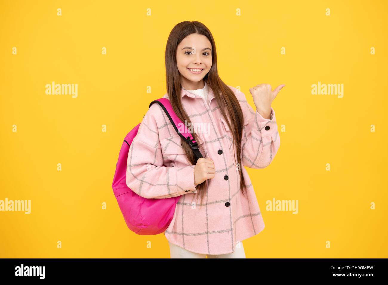 happy teen girl wear pink checkered shirt carry school backpack, education Stock Photo