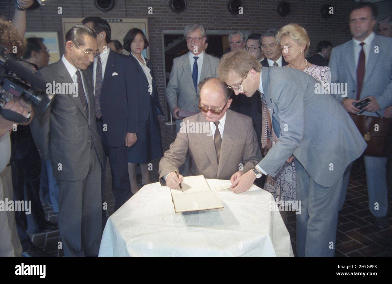 Japonia Kioto 02.07.1987. Ostatni dzieñ oficjalnej wizyty przewodnicz¹cego Rady Pañstwa PRL Wojciecha Jaruzelskiego w Japonii. Polska delegacja obejrza³a kolekcjê Sumitomo - zbiór staro¿ytnych przedmiotów z br¹zu pochodz¹cych z Chin w Muzeum Sen Oku Hakko Kan. Nz. m.in.: Wojciech Jaruzelski wpisuje siê do ksiêgi pami¹tkowej muzeum, Barbara Jaruzelska (2P), szef protoko³u dyplomatycznego Roman Czy¿ycki (w g³êbi C). uu  PAP/Grzegorz Rogiñski       Japan Kyoto 02 July 1987. The last day of the official visit of chairman of the State Council in Japan. The Polish delegation seeing the Sumitomo coll Stock Photo