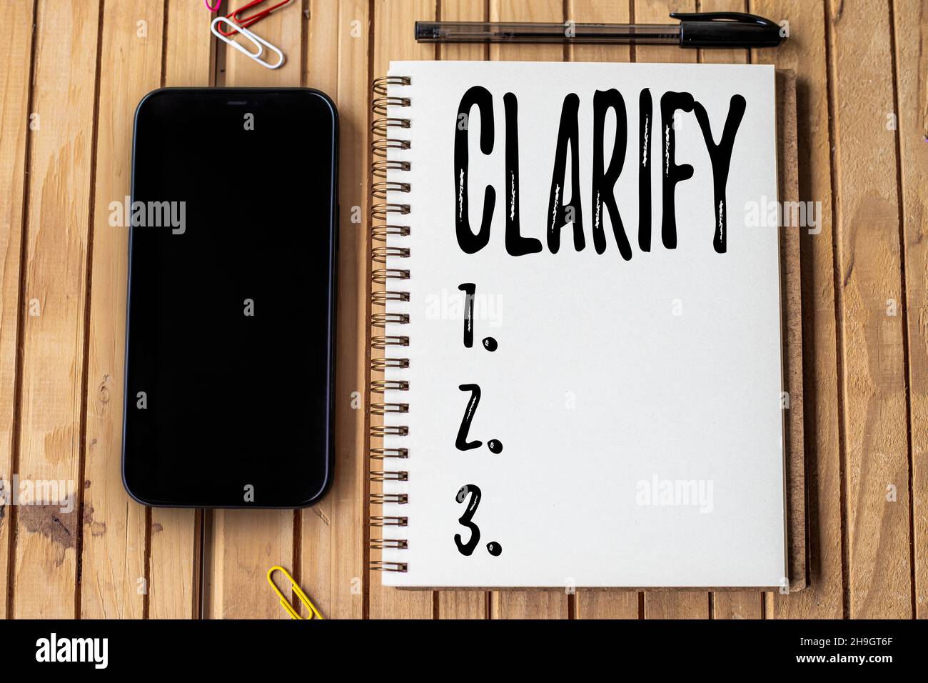 Text sign showing Clarify. Business approach Make a statement or situation less confused and more comprehensible Empty Open Journal Beside Mobile With Stock Photo