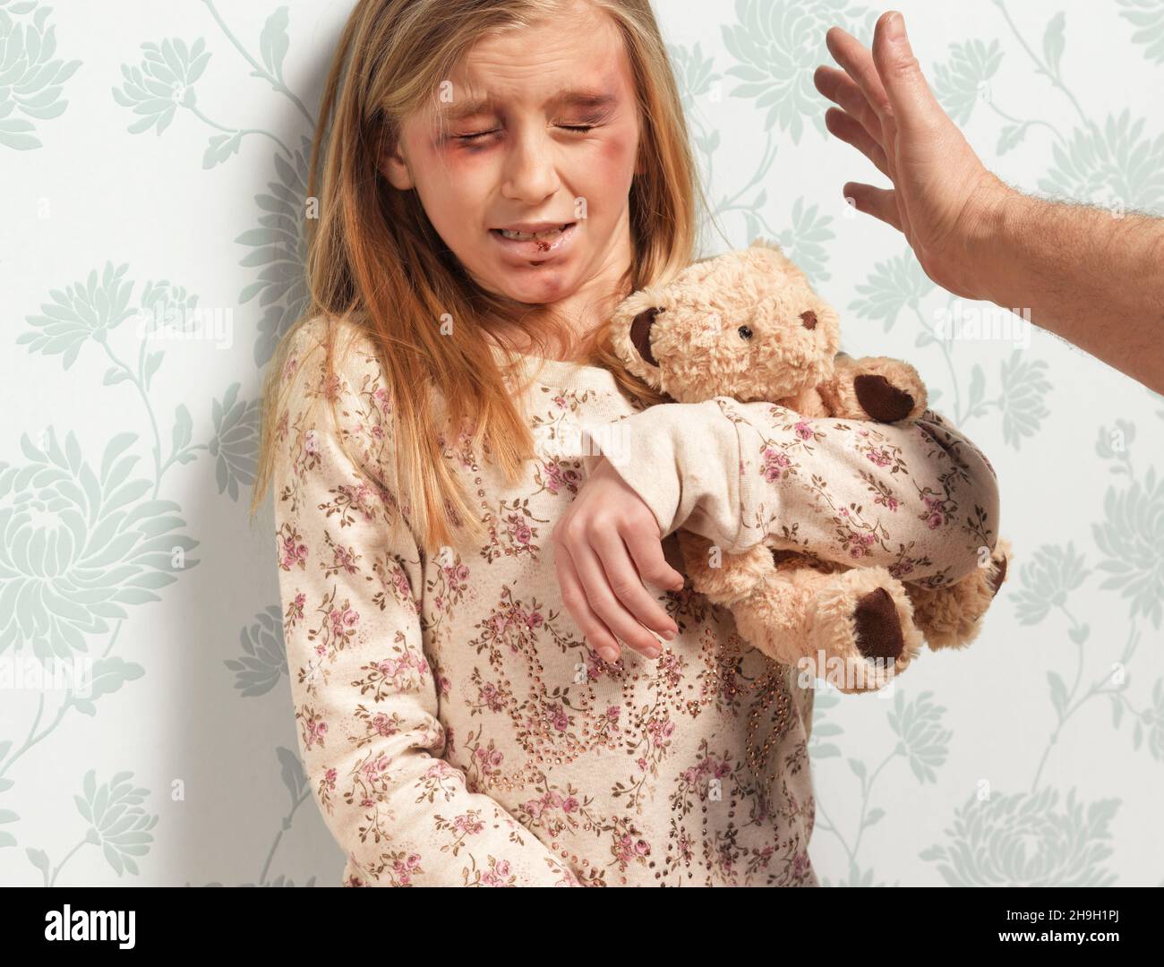 Domestic abuse, hand hitting cowering child Stock Photo