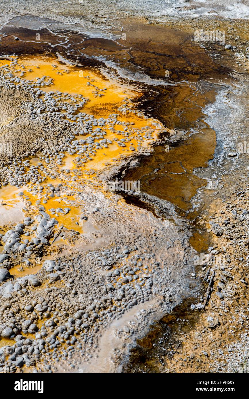 Vertical shot of cracked wet rocks and a steam coming out of them. Stock Photo