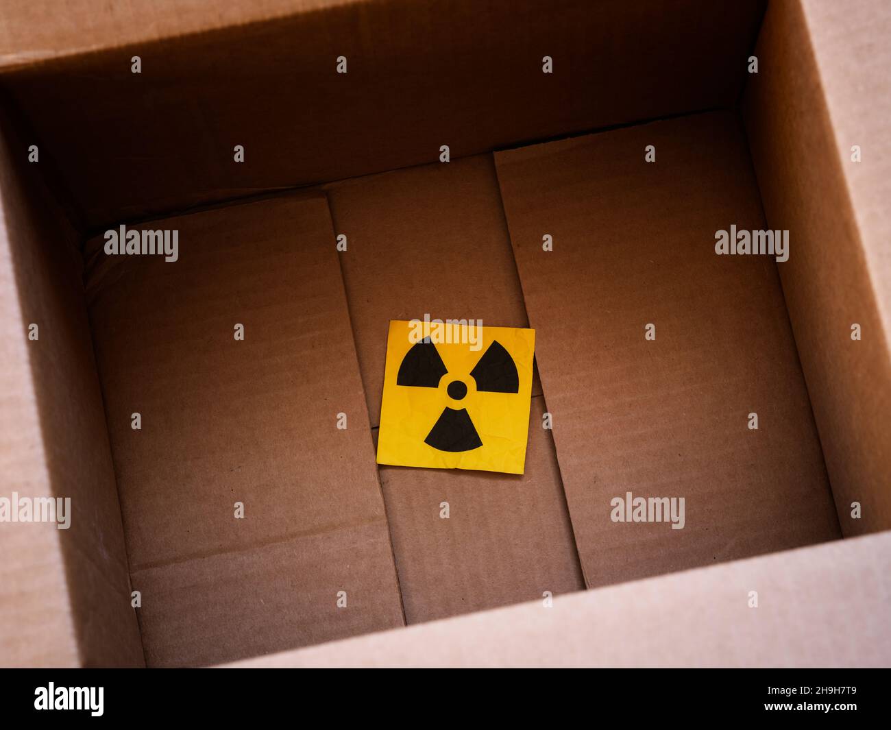 A radiation warning sign in a cardboard box. Close up. Stock Photo