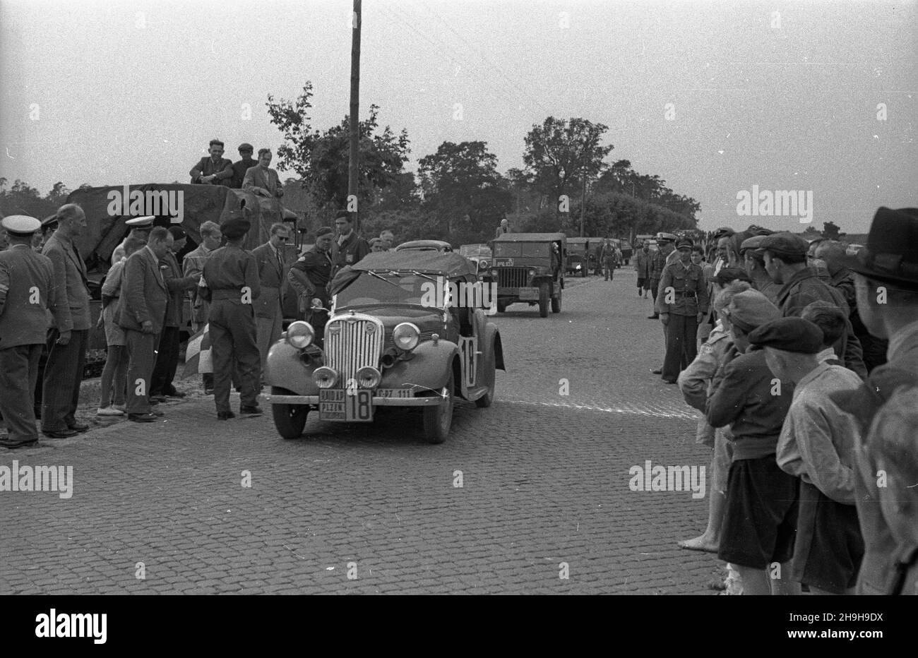 Jab³onna, 1948-07-03. XIV Miêdzynarodowy Rajd Automobilklubu Polskiego o Grand Prix Polski. Nz. na starcie zawodnik czeski Suttnar w samochodzie Singer Roadster, z ty³u willys.  bk  PAP      Jablonna, July 3, 1948. The 14th International Car Rally of Poland's Automobile Club for the Grand Prix of Poland. Pictured: Czech's Suttnar in Singer Roadster, behind him a willys.   bk  PAP Stock Photo