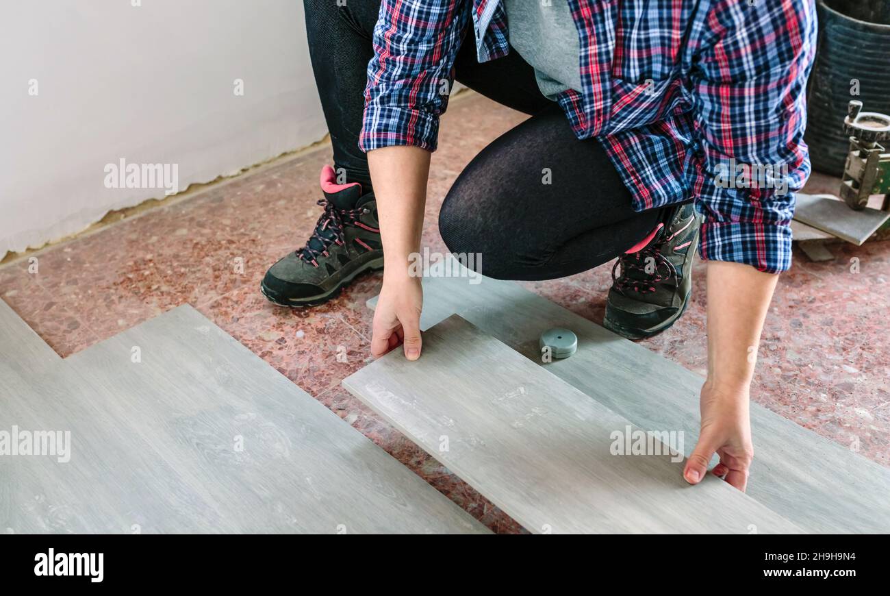 Female bricklayer placing tiles to install a floor Stock Photo Alamy