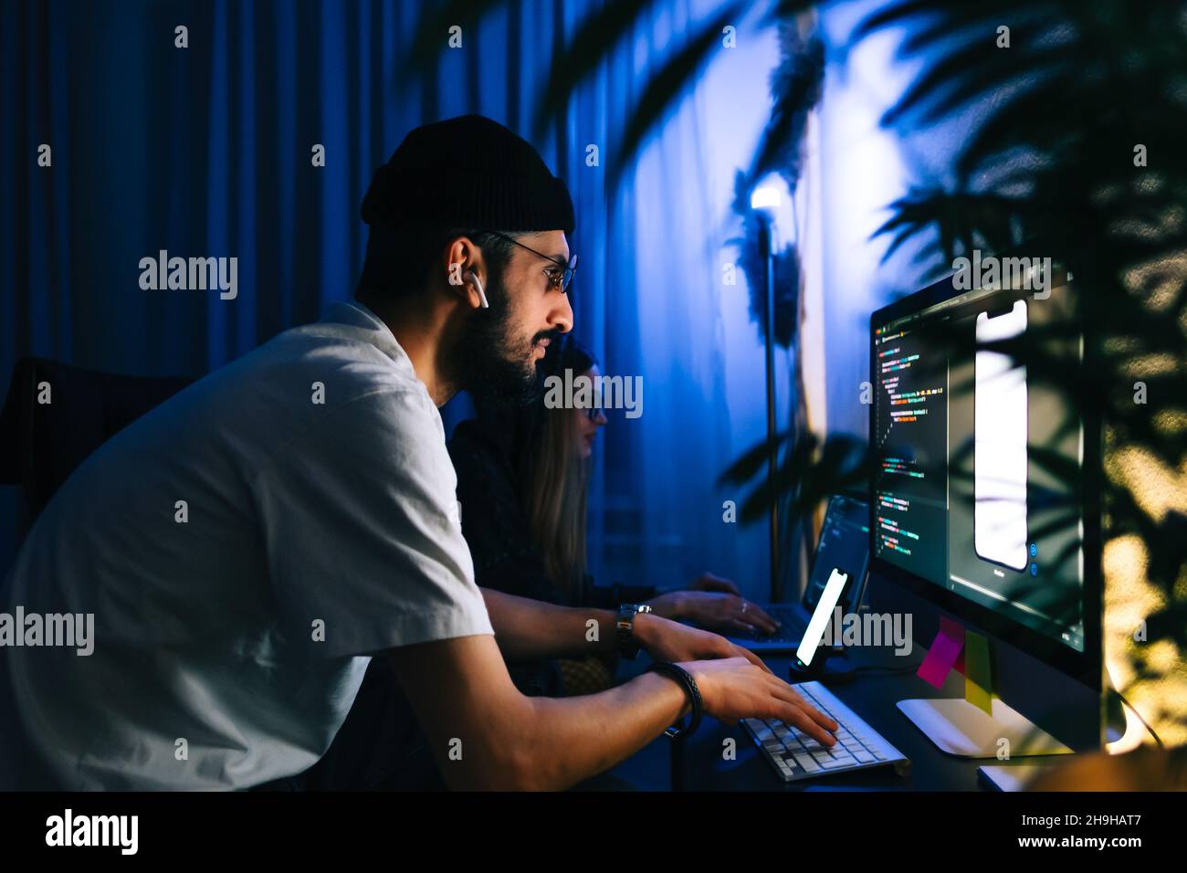 Mobile developers team writes program code on a computer, programmers work in home office. Stock Photo
