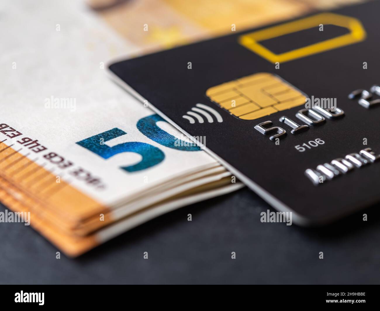 Credit card on fifty euro banknotes macro. Black debit cards for cash withdrawals and payments for goods and services. Bank charge card and money Stock Photo - Alamy