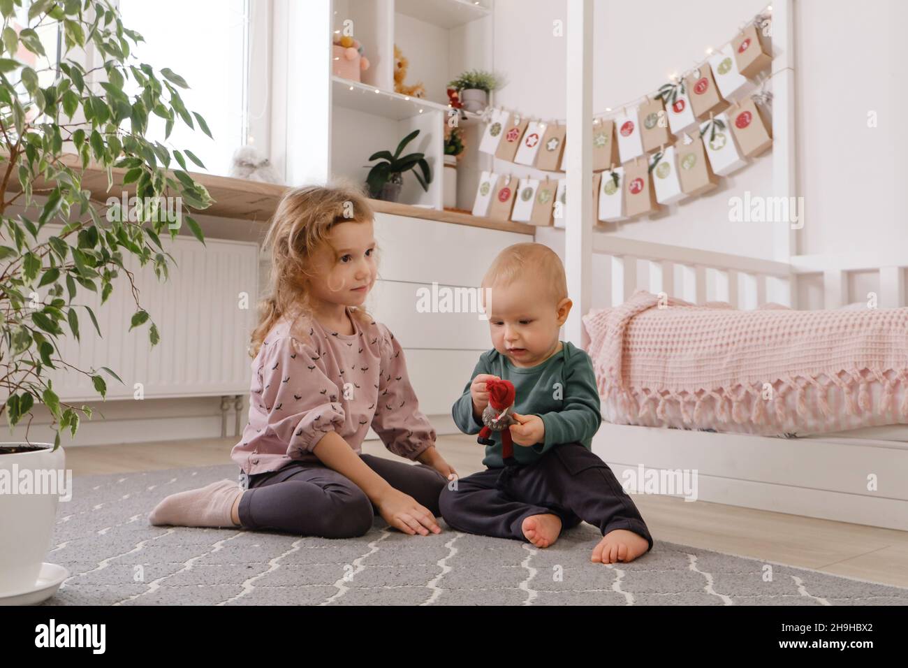 Sister and brother playing in the room before Christmas near advent