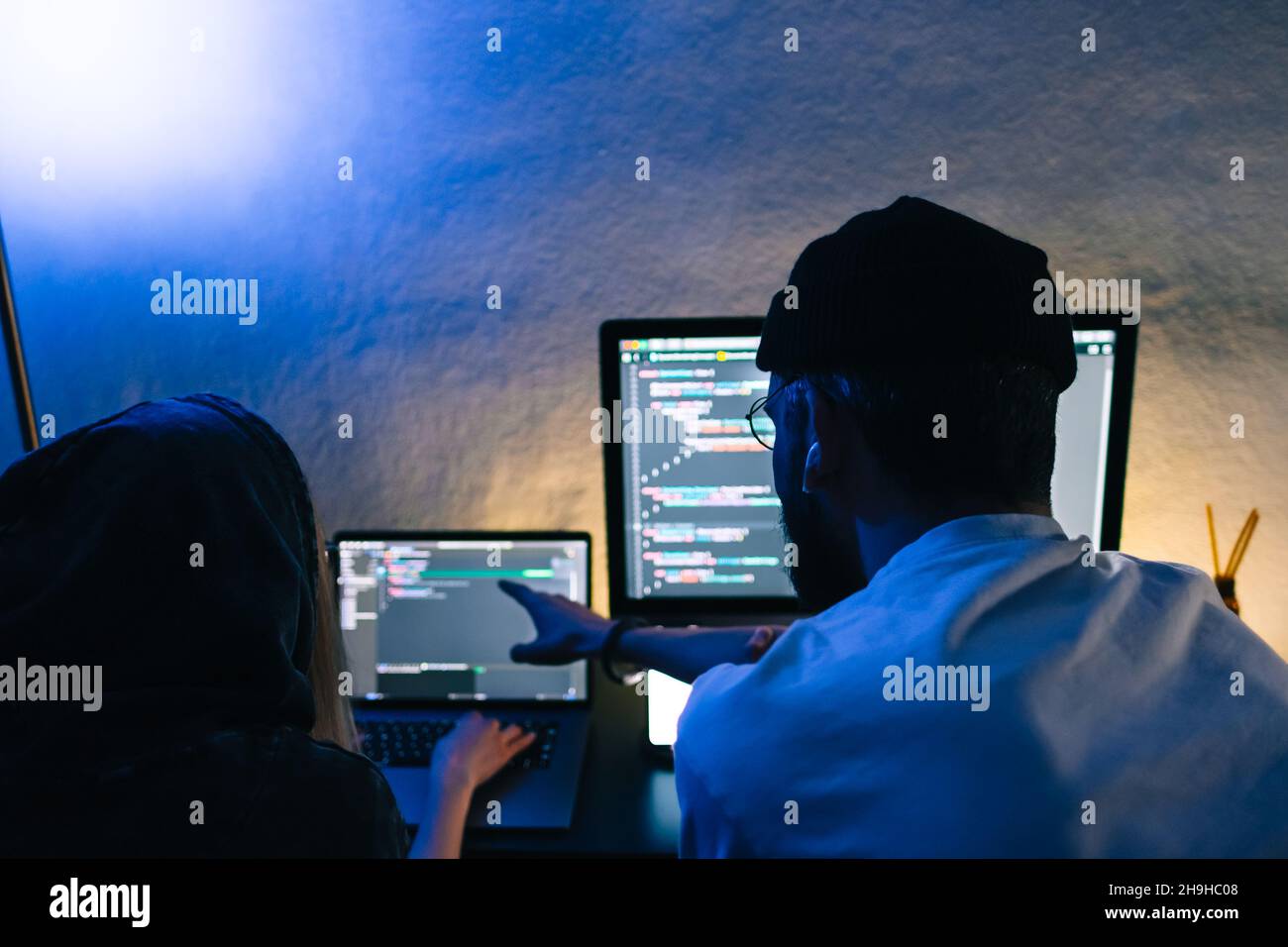 Mobile developers team writes program code on a computer, programmers work in home office. Stock Photo