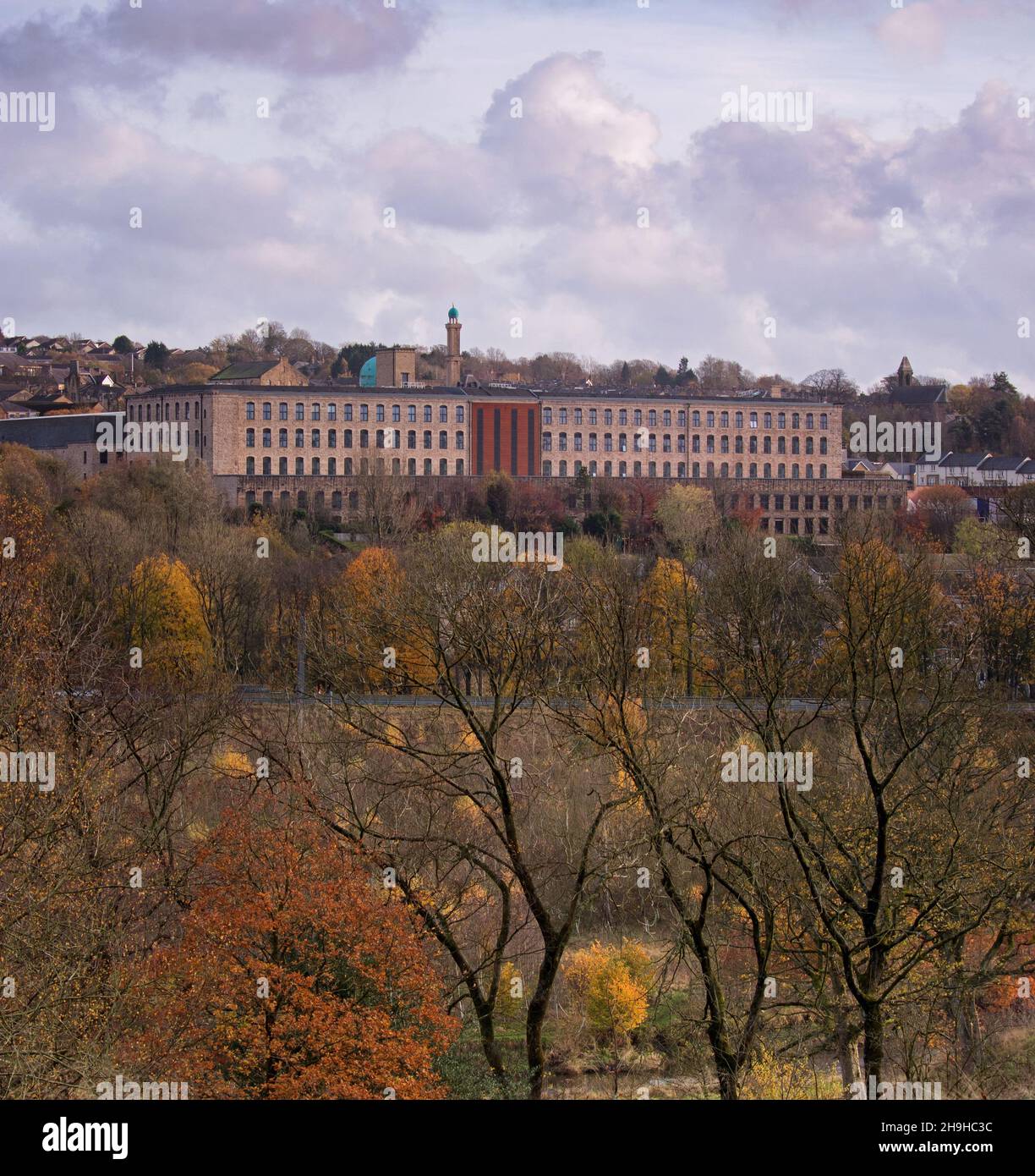 Autumn colours in the foreground, with the renovated building of Tunstill Mill in the distance, surrounded by local Brierfield architecture Stock Photo