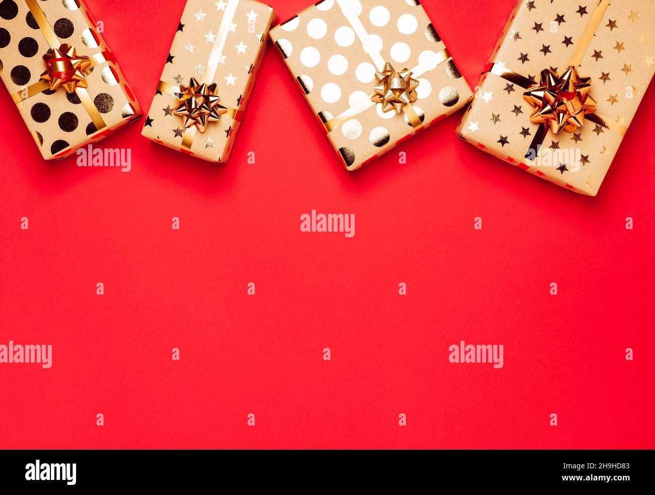 Gift boxes with golden bows and ribbons on red background Stock Photo ...