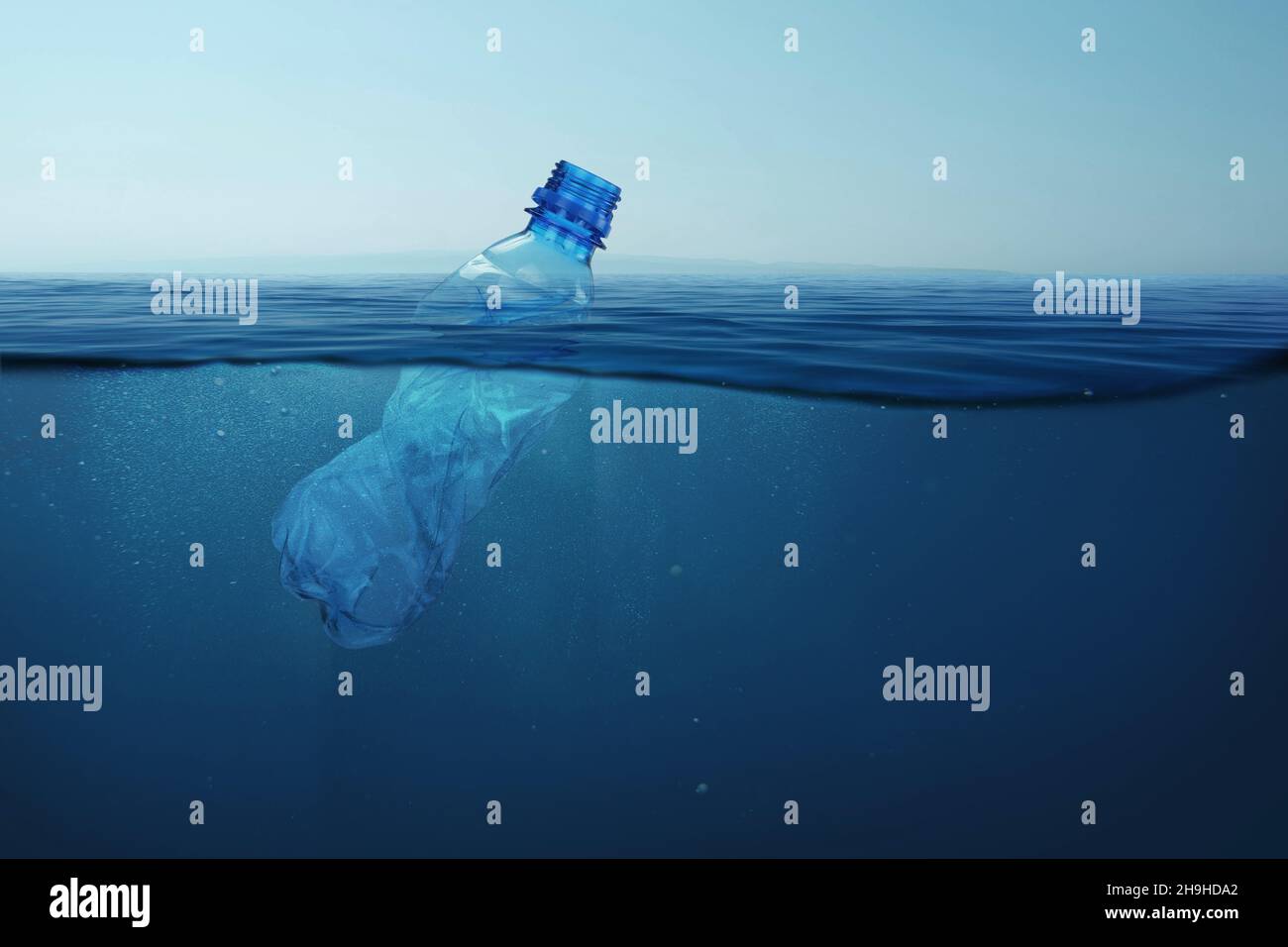 Garbage plastic bottle floats in blue sea water with underwater