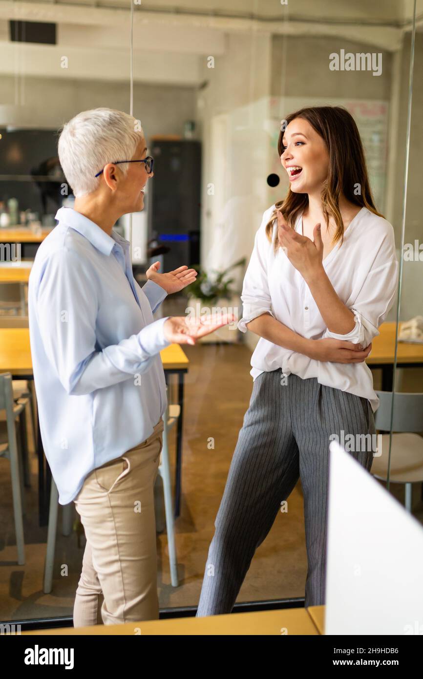 Portrait of happy success business women talking and having fun in office Stock Photo