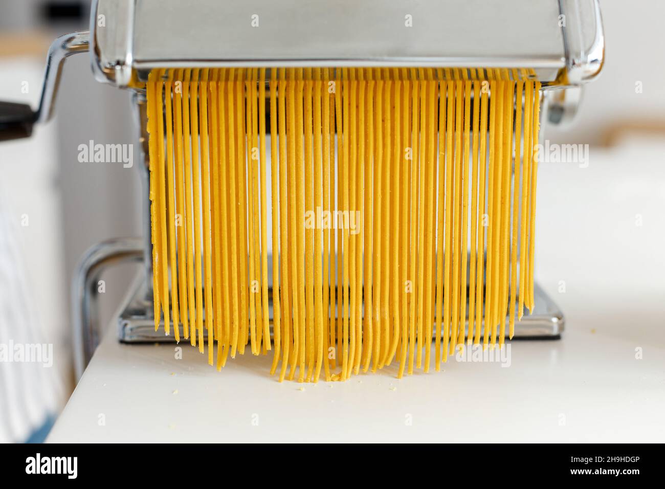https://c8.alamy.com/comp/2H9HDGP/man-in-apron-making-spaghetti-with-noodle-cutter-close-up-pasta-cooking-at-home-preparing-food-from-bright-yellow-dough-2H9HDGP.jpg