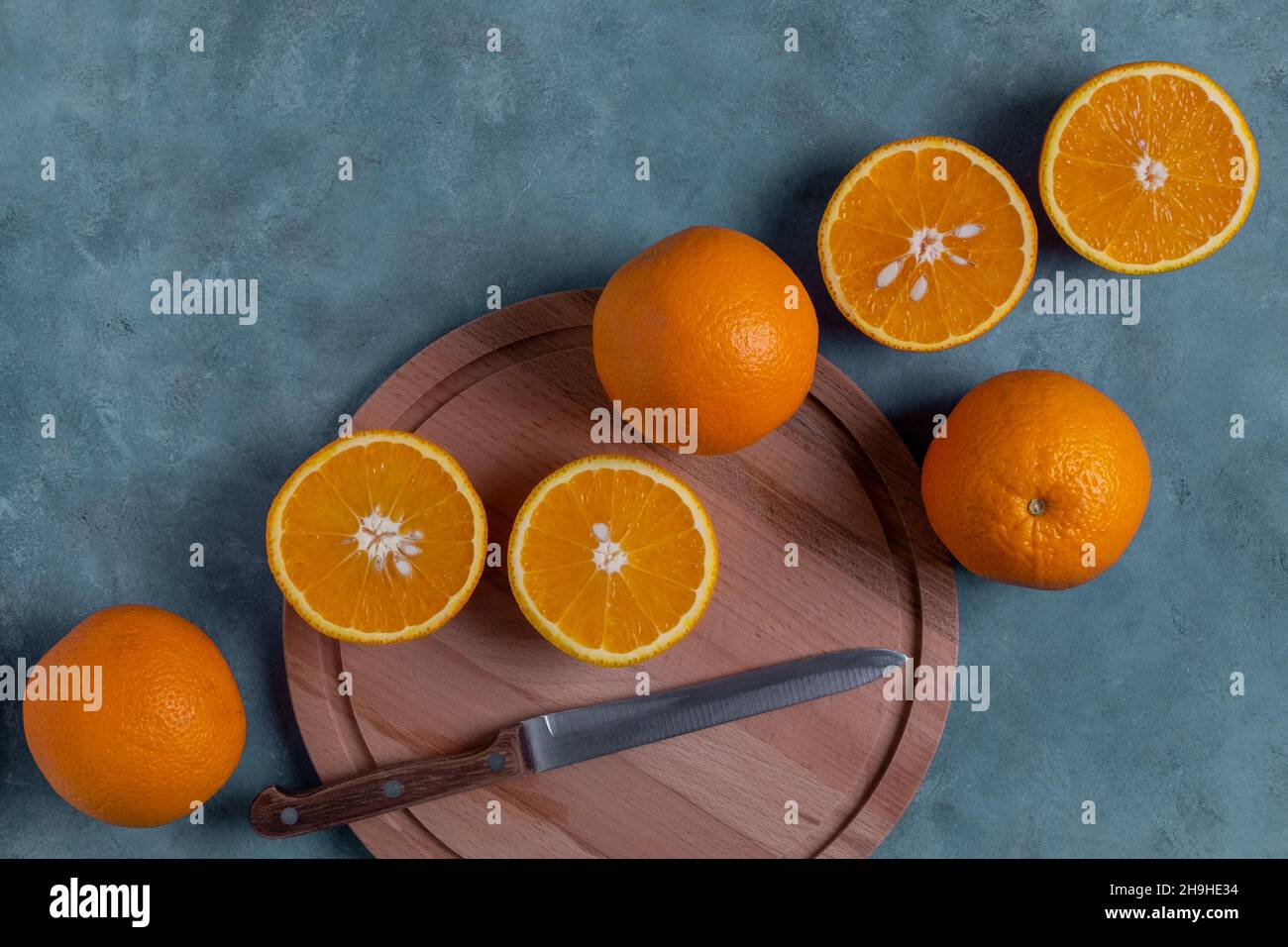 Close-up top view of ripe whole and halved oranges. Stock Photo
