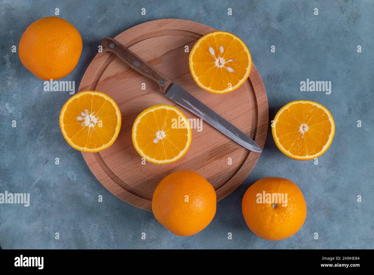 Close-up top view of ripe whole and halved oranges. Stock Photo