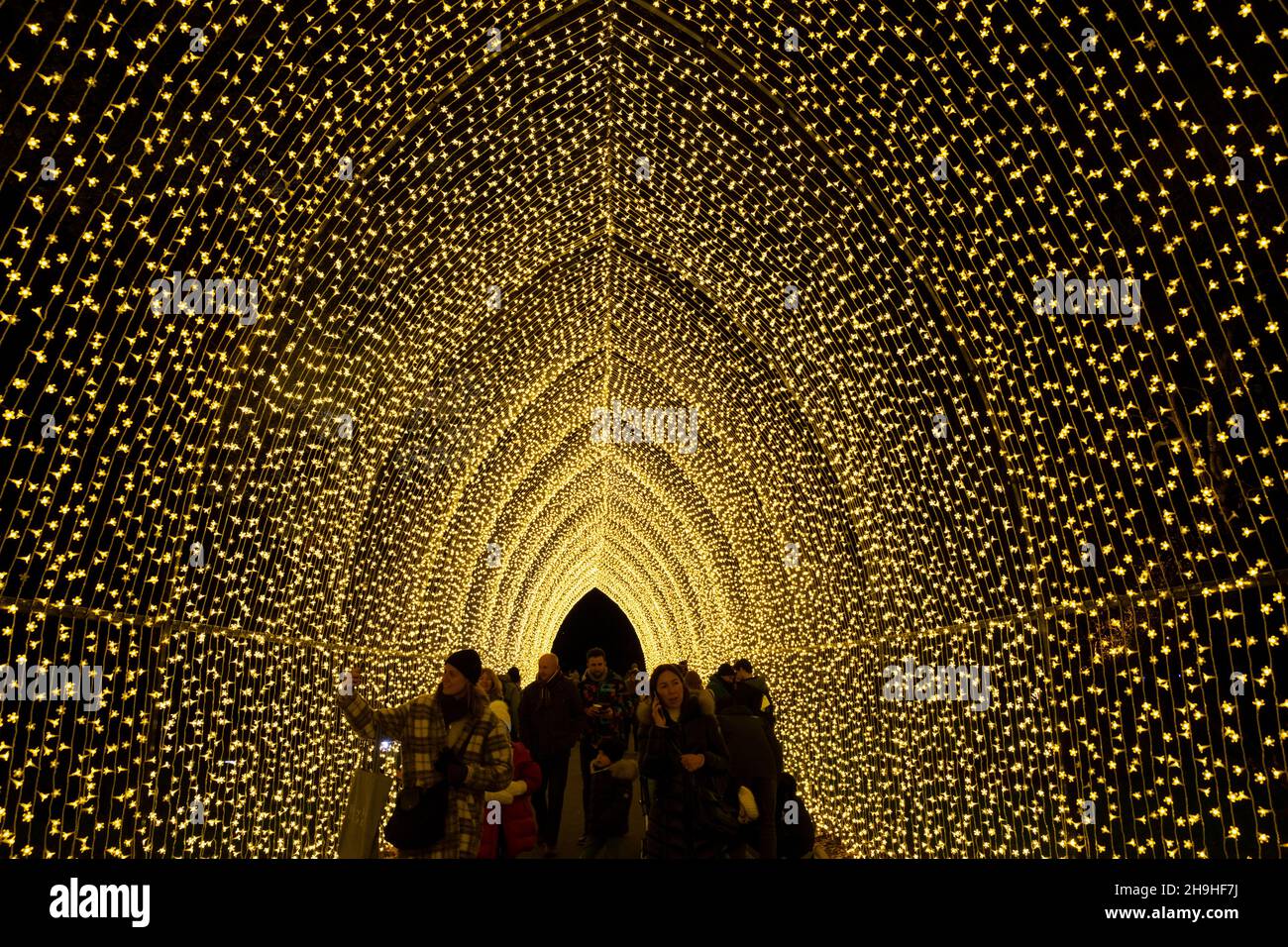 People walked through an arch of lights during Christmas light show at Kew Gardens, London, UK