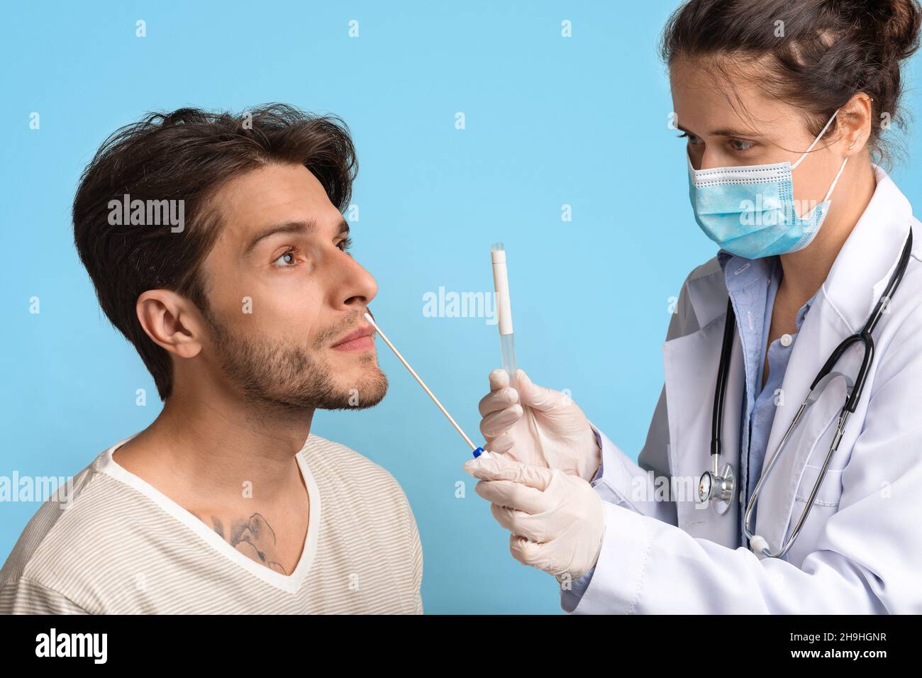 PCR Coronavirus Test. Female Doctor Taking Swab From Male Patient's Nose Stock Photo