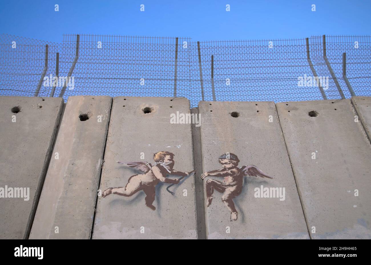 Banksy street art in Bethlehem - two Putti attempting to pry their way through the ‘great wall’. Stock Photo
