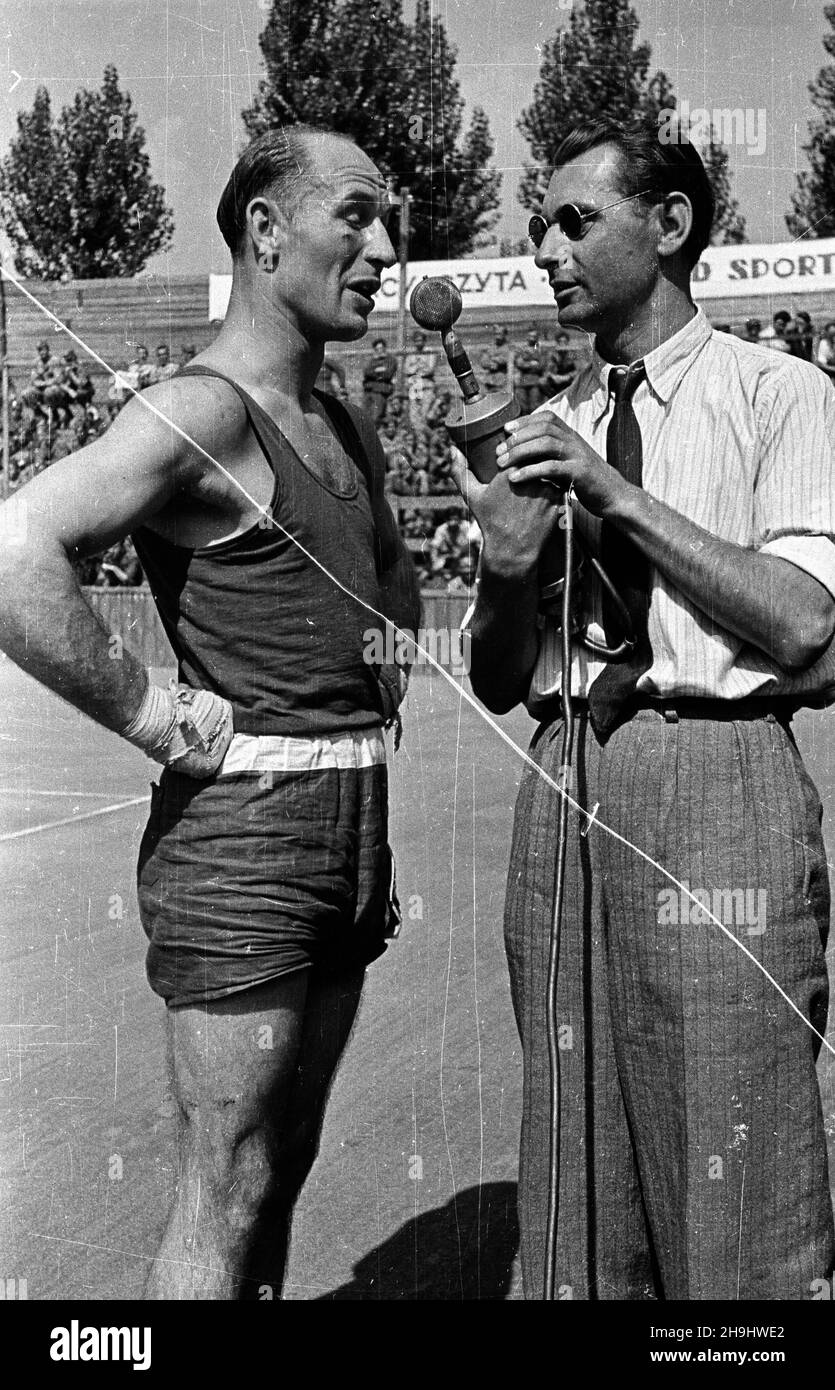 Warszawa, 1948-08. Pierwsze ogólnopolskie Igrzyska Sportowe Zwi¹zków Zawodowych (19-22.VIII) na stadionie Wojskowego Klubu Sportowego Legia, w których rywalizowali w 11 dyscyplinach reprezentanci 17 zwi¹zków zawodowych. Nz. zawody bokserskie, zwyciêzca w wadze pó³œredniej Gr¹dkowski (Budowlani) udziela wywiadu sprawozdawcy Polskiego Radia Tadeuszowi Pyszkowskiemu. ka PAP Dok³adny dzieñ wydarzenia nieustalony. Warsaw, Aug. 1948. The first national Trade Union Sports Competition (Aug. 19-22) held at the stadium of the Military Sports Club Legia. The event brought together representatives Stock Photo
