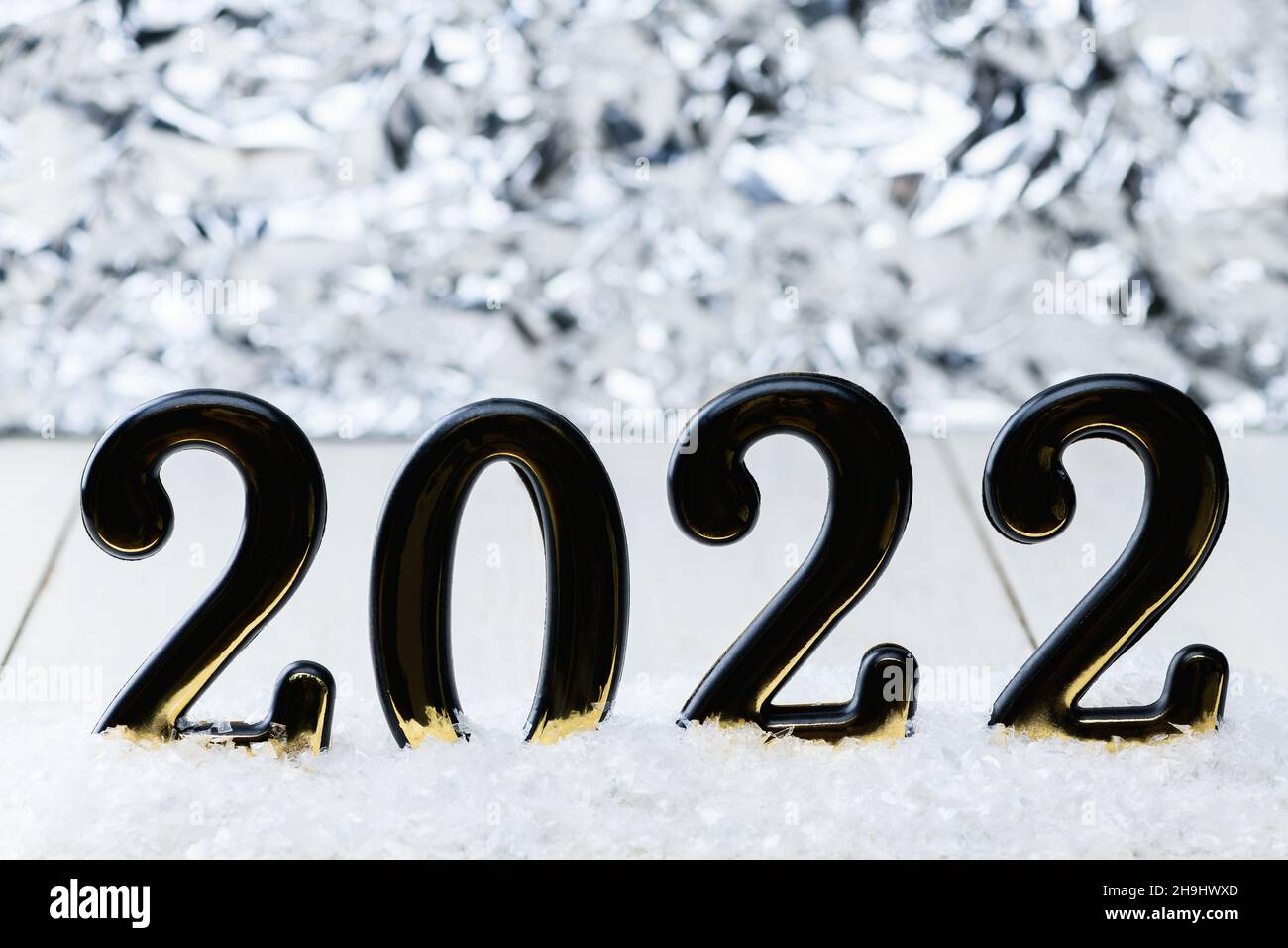 Black numbers 2022 on white background with snow. New year backdrop with 2022 year Stock Photo