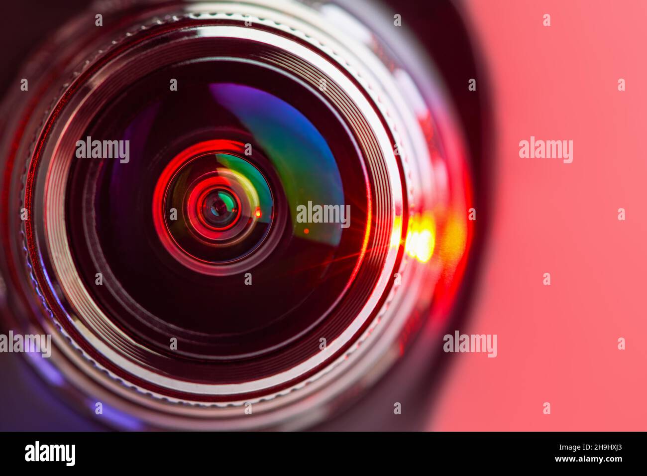 The camera lens and the red backlighting. Red  camera Lens close Up. horizontal photo Stock Photo