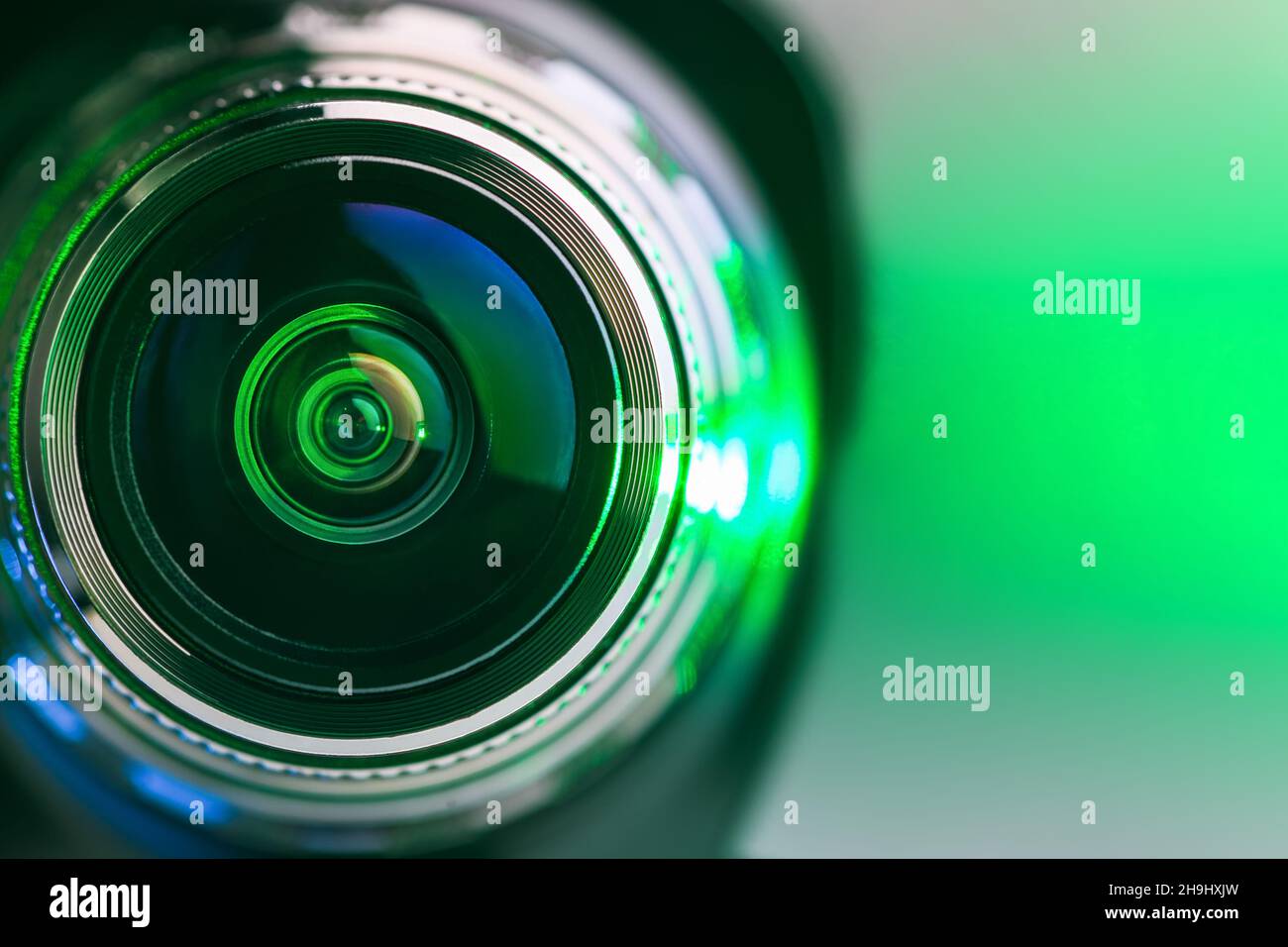 The camera lens and green backlighting. Green camera Lens close Up. Horizontal photo Stock Photo