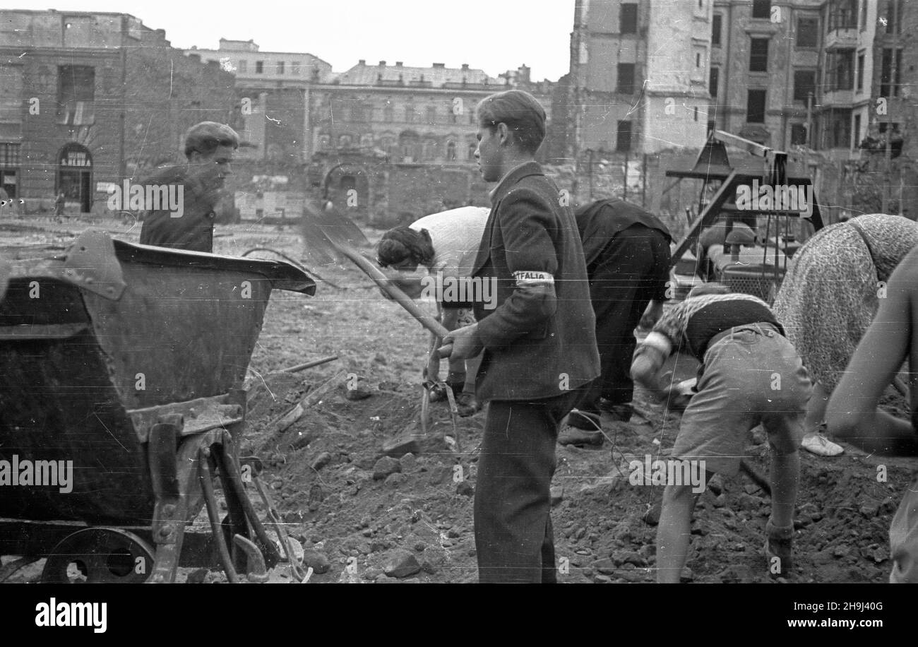 Warszawa, 1948-08. Na zaproszenie w³adz Polski 3 tysi¹ce dzieci Polaków z zagranicy spêdzi³o wakacje na koloniach zorganizowanych w ca³ym kraju. Pod koniec pobytu m³odzie¿ odwiedzi³a Warszawê i pomaga³a w odgruzowywaniu miasta. Nz. prace na ulicy Marsza³kowskiej, na wysokoœci placu D¹browskiego. Po lewej ruiny kamienicy Hersego, w g³êbi po prawej kamienica Goldstanda, obok centralnie pa³ac Szlenkiera.  ka  PAP  Dok³adny dzieñ wydarzenia nieustalony.      Warsaw, Aug. 1948. Three thousand children of Poles living abroad spent their vacations in Poland at camps all over the country. At the end o Stock Photo