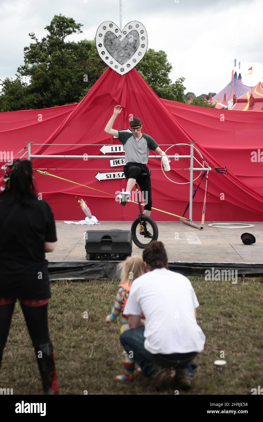A unicyclist attempting to pour a bowl of cornflakes while on his