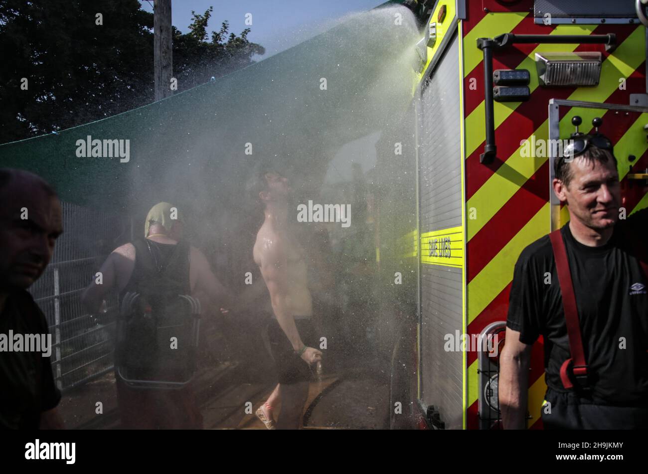 A man is doused by Shepton Mallet firemen on a very hot Day 1 (Wednesday) of the 2017 Glastonbury Festival at Worthy Farm in Somerset. Photo date: Wednesday, June 21, 2017. Photo credit should read: Richard Gray/EMPICS Entertainment Stock Photo
