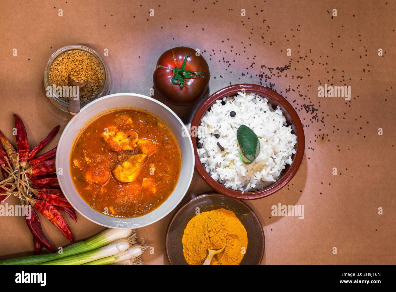 Madras chicken curry and basmati rice in bowl, spices (turmeric