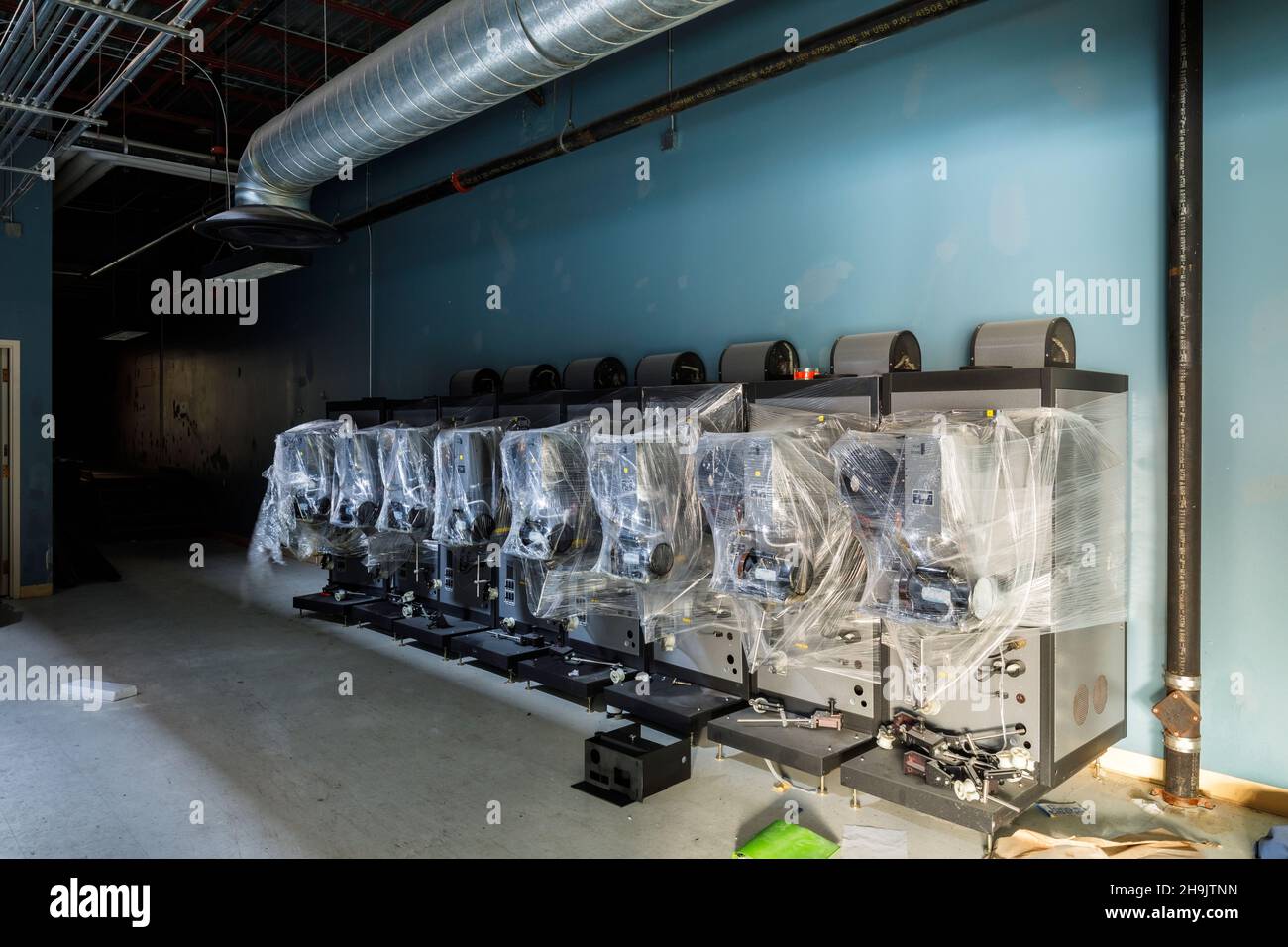 Analogue movie projectors wrapped in plastic.  This location has since been demolished. Stock Photo