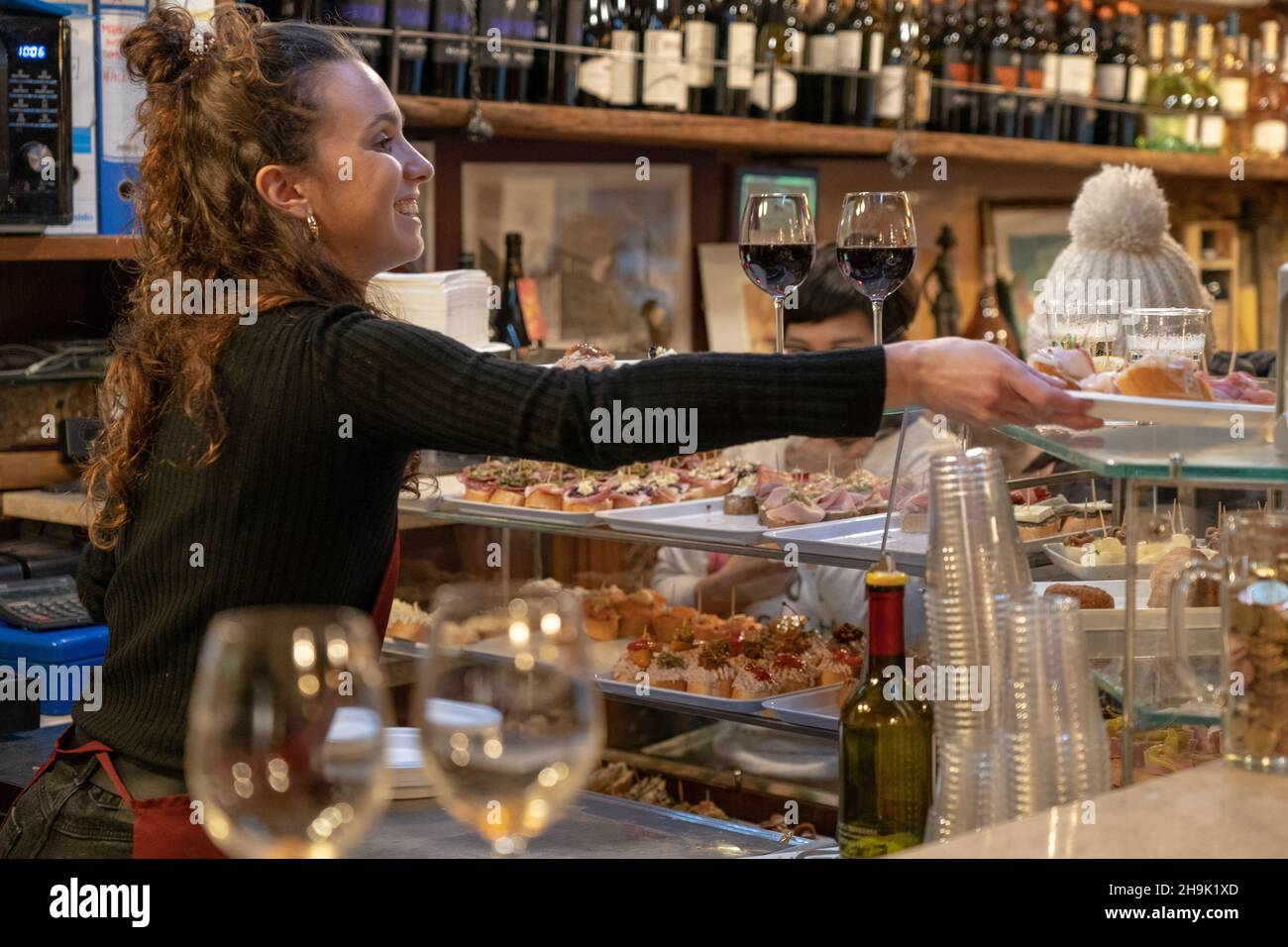 A woman serving chicheti (small snacks) in a bar in Venice. From a