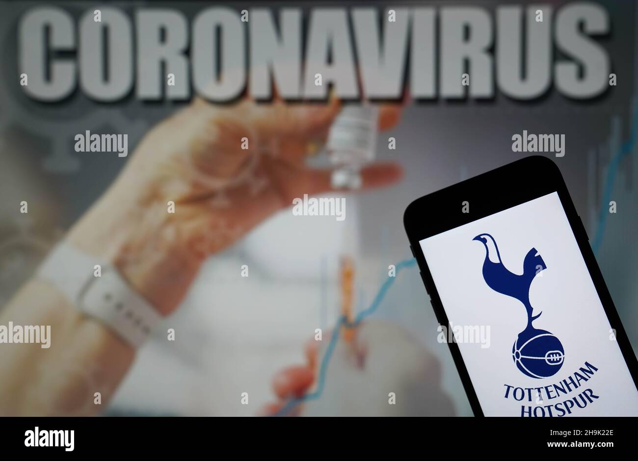 File photo dated 09-01-2021 of The Tottenham Hotspur Football Club logo seen displayed on a mobile phone with a Coronavirus illustration on a monitor in the background. Tottenham's plans to manage a busy period of games have been hindered by a coronavirus outbreak at the club. Issue date: Tuesday December 7, 2021. Stock Photo