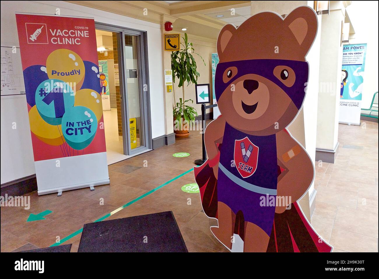 Graphic poster and cartoon character inside a Covid-19 Vaccine Clinic. Stock Photo