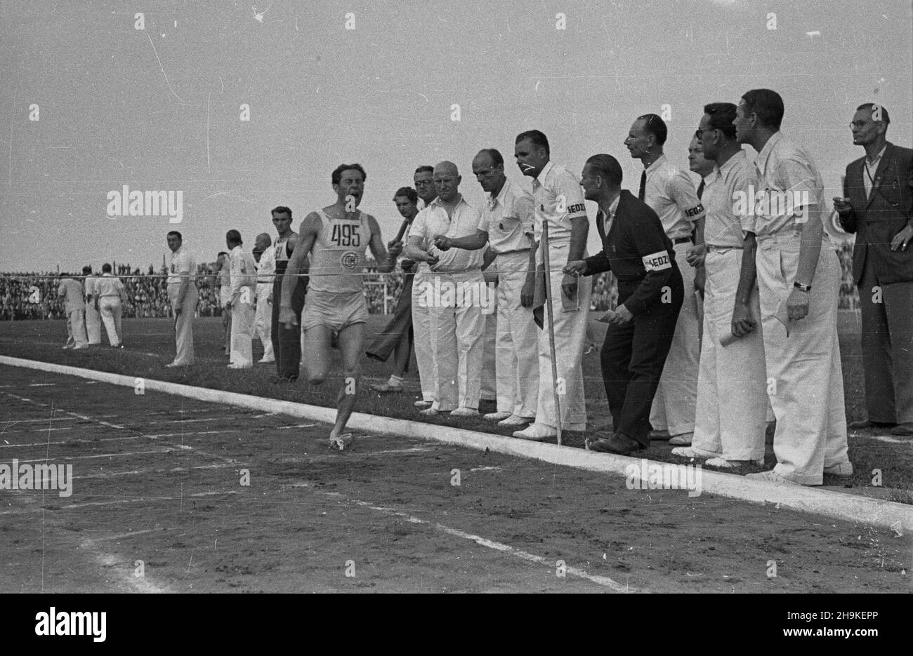 Warszawa, 1948-08-22. Pierwsze ogólnopolskie Igrzyska Sportowe Zwi¹zków Zawodowych (19-22 VIII) na stadionie Wojskowego Klubu Sportowego Legia, w których rywalizowali w 11 dyscyplinach reprezentanci 17 zwi¹zków zawodowych. Nz. finiszuje sztafeta Zwi¹zku Zawodowego Metalowców. ka PAP Warsaw, Aug. 22, 1948. The 1st National Trade Unions' Olympics (Aug. 19-22) on Legia, the military sports club in which representatives of 17 trade unions competed in 11 disciplines. Pictured: a member of the Metal Workers Trade Unions' relay team crosses the finishing line. ka PAP Stock Photo