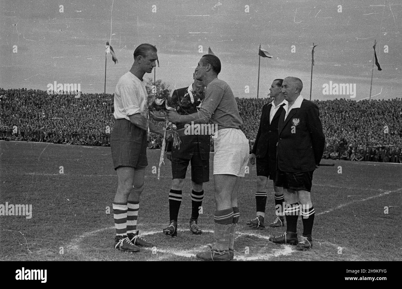 Warszawa, 1948-08-25. Mecz pi³ki no¿nej pomiêdzy reprezentacjami Polski i Jugos³awii (0:1) na stadionie Wojskowego Klubu Sportowego Legia. Nz. przywitanie kapitanów dru¿yn Tadeusza Porpana (1L) z Miroslavem Brozovicem (3L). Obok sêdziowie: g³ówny Niemcovsky (2P) i liniowy Kmiciñski (1P). ka PAP/Stanis³aw D¹browiecki Warsaw, Aug. 25, 1948. The soccer match between Polish and Yugoslav teams (0:1) at Legia, the military sport club. Pictured: captain Tadeusza Porpana (1st left) greets Miroslavem Brozovicem (3rd left). Next to them assistant referees Michalik (2nd left) and Kmicinski (1st ri Stock Photo