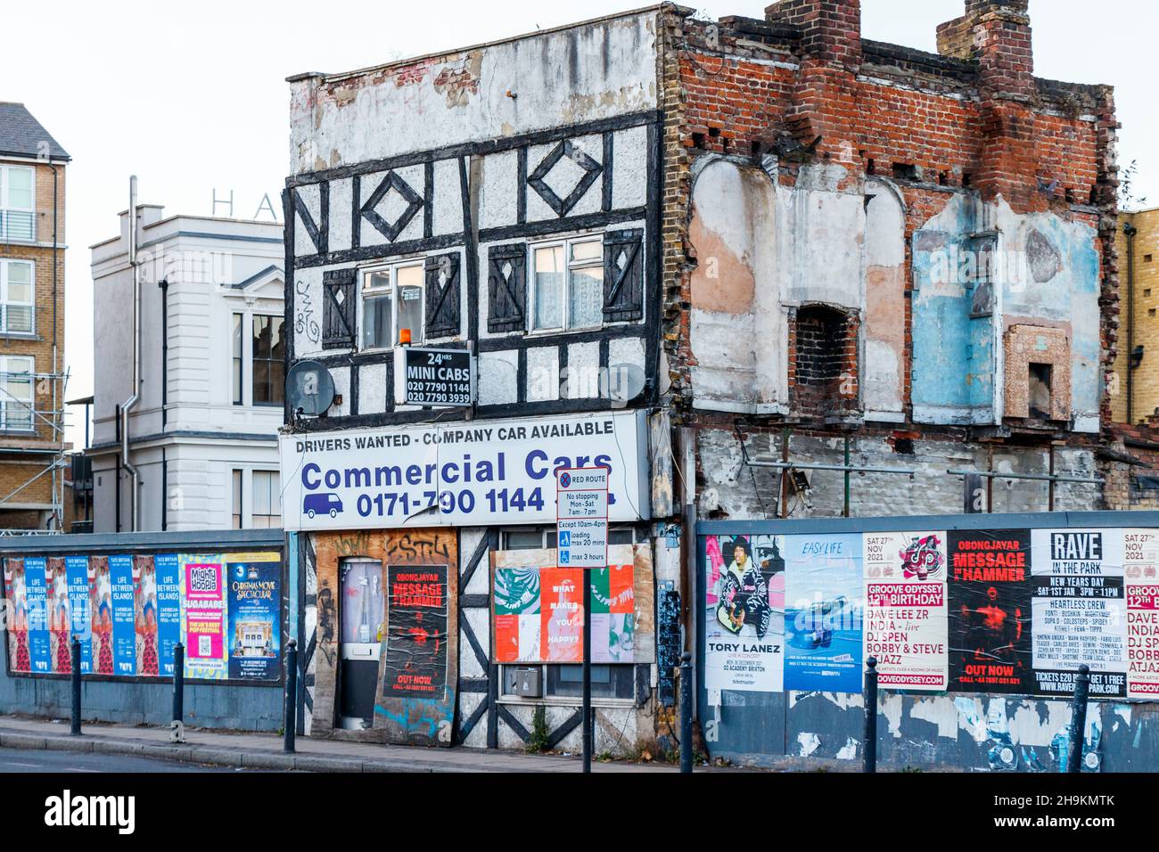 A minicab firm in the last-standing property in a row of demolished buildings in Commercial Road, LImehouse, London, UK Stock Photo
