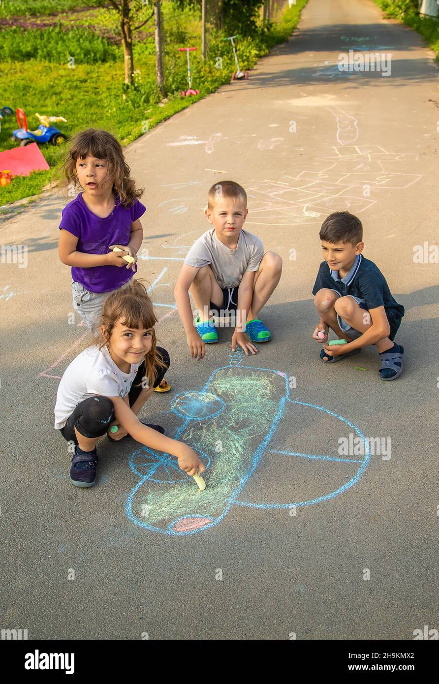 Children Drawing On A Pavement With Chalk High Resolution Stock ...