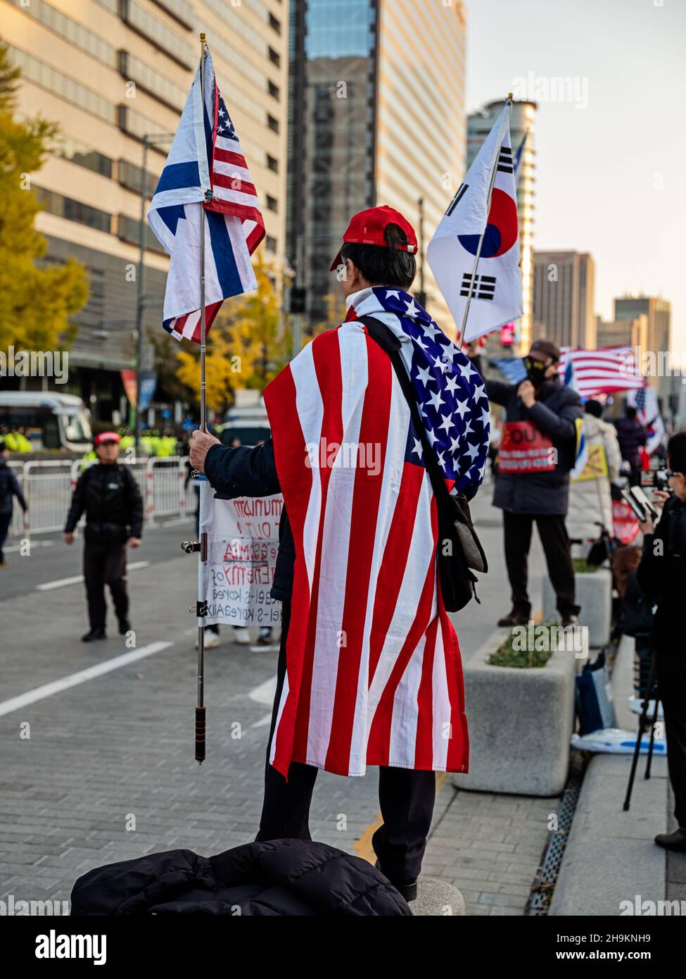 SEOUL, KOREA - NOVEMBER 16, 2019: An anonymous Korean man wrapped in an American flag protests against the policies of President Moon Jai-In during a Stock Photo