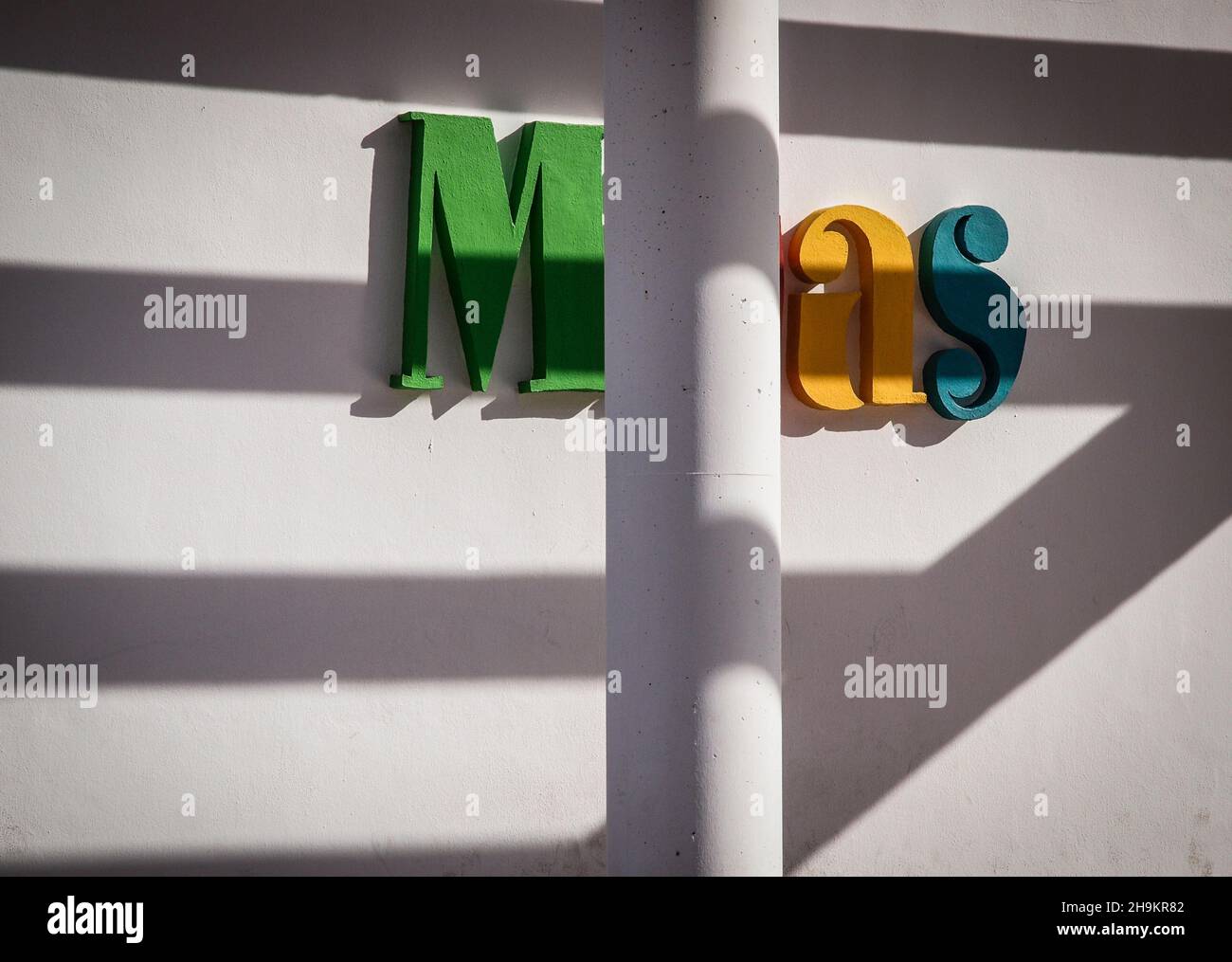 Letters M,a and s on a facade with bright sunlight and a column in front of it Stock Photo