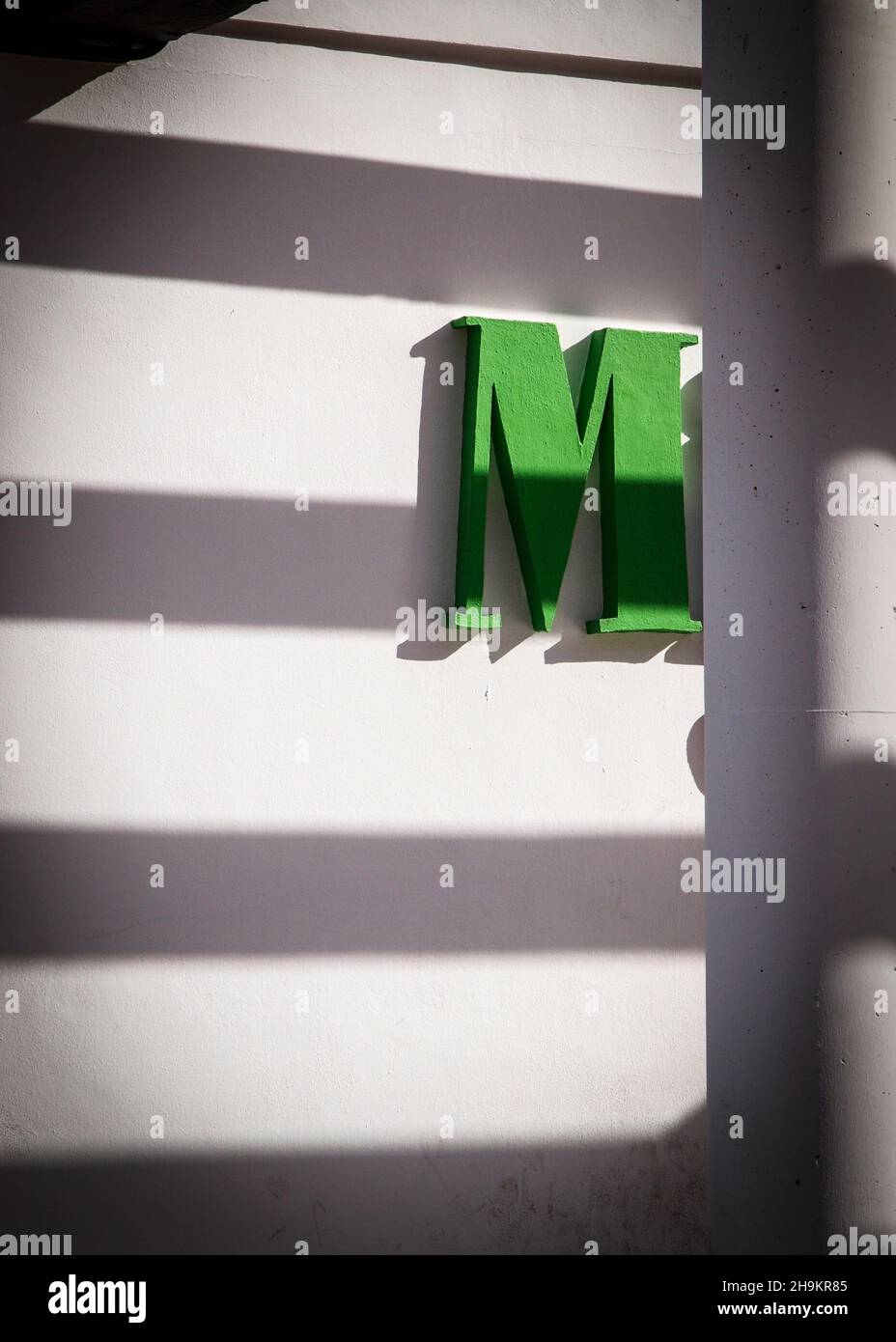 Letters M,a and s on a facade with bright sunlight and a column in front of it Stock Photo