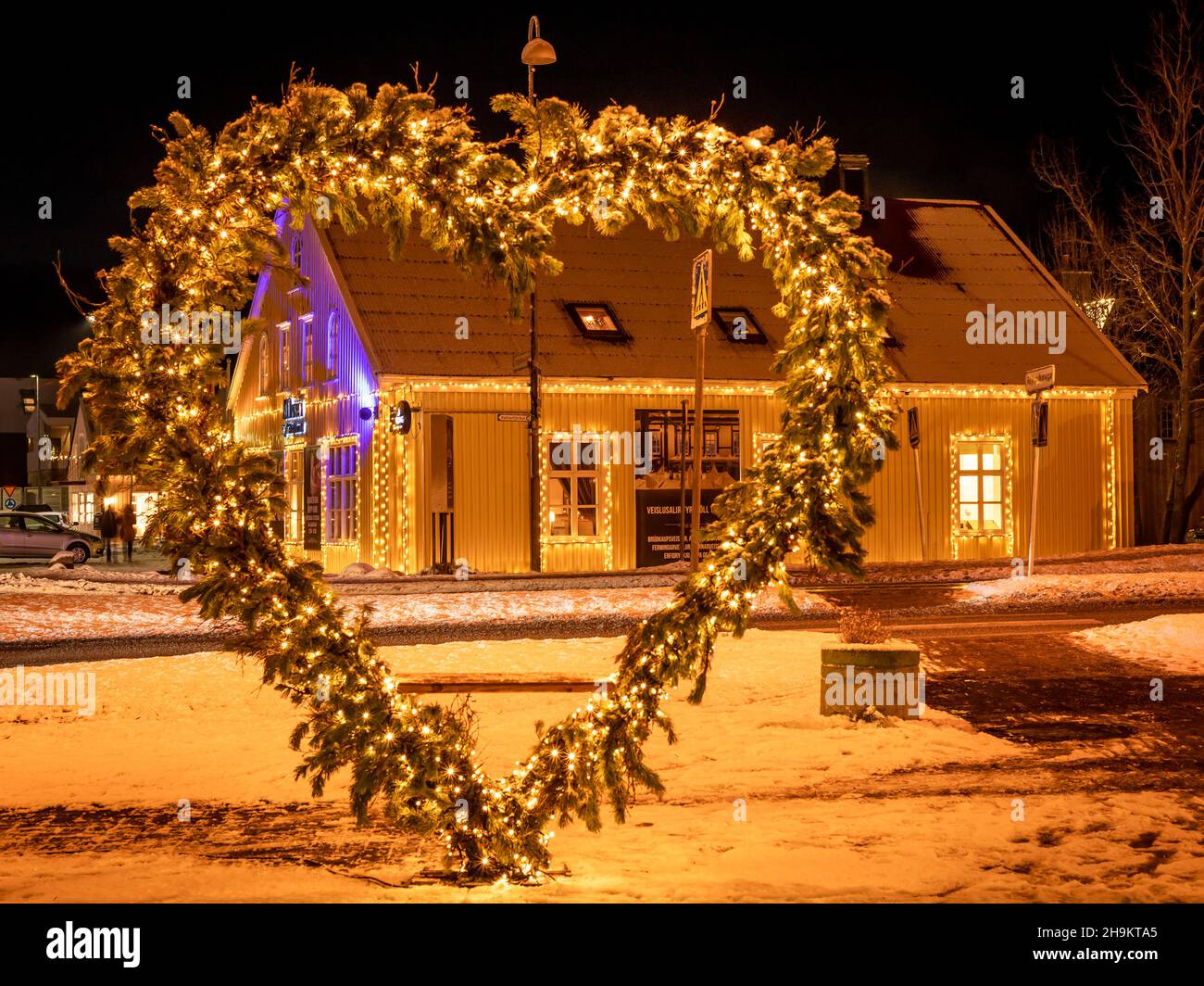 Hafnarfjordur, Iceland - December 4, 2021: A. Hansen Restaurant, illuminated with Christmas lights and a heart-shaped decoration. Winter night. Stock Photo