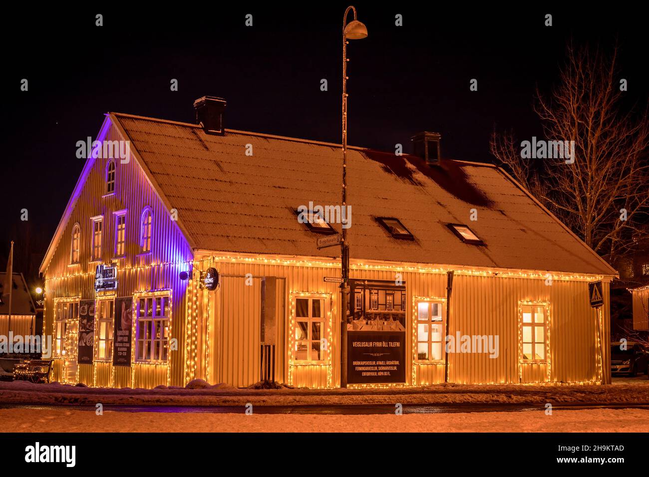 Hafnarfjordur, Iceland - December 4, 2021: Old historical cottage of A. Hansen Restaurant and bar, illuminated with Christmas lights. Winter night. Stock Photo