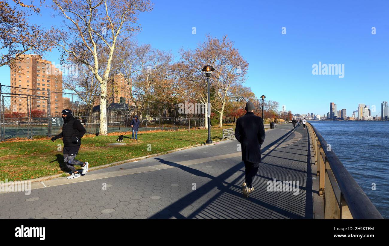 Joggers and people on the East River Waterfront Esplanade in East River Park in the Lower East Side of Manhattan, New York, NY. November 23, 2021. Stock Photo