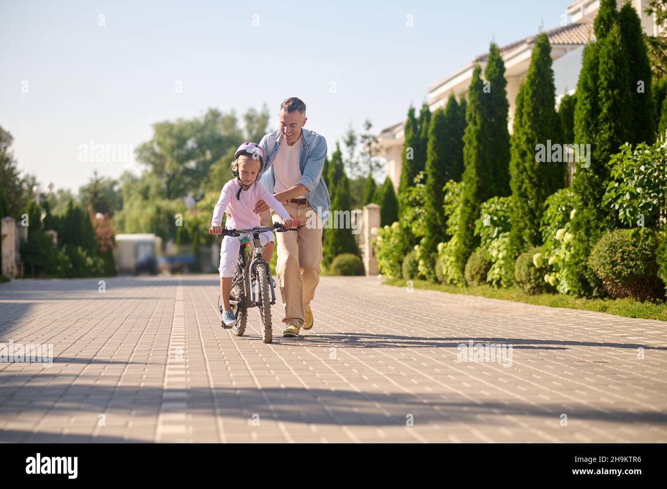 daugther sit and riding Dad riding a bike with his daughter sitting on it Stock Photo - Alamy