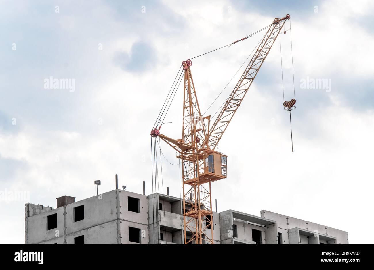 Crane and building construction against blue sky. Stock Photo