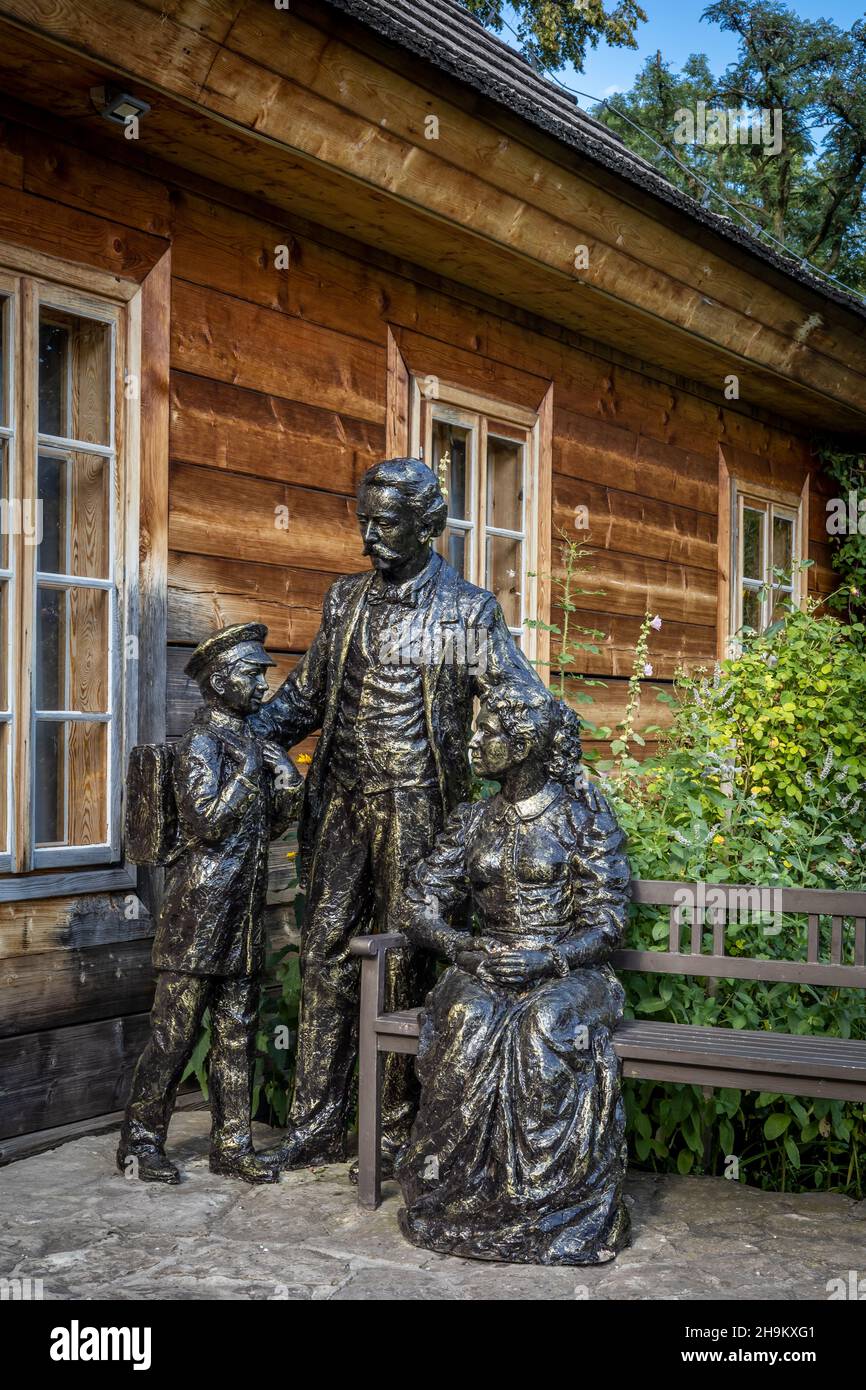 Ciekoty, Poland  - July 29, 2021: Sculptures of a famous Polish writer, Stefan Zeromski family, in front of their reconstructed wooden house. Stock Photo