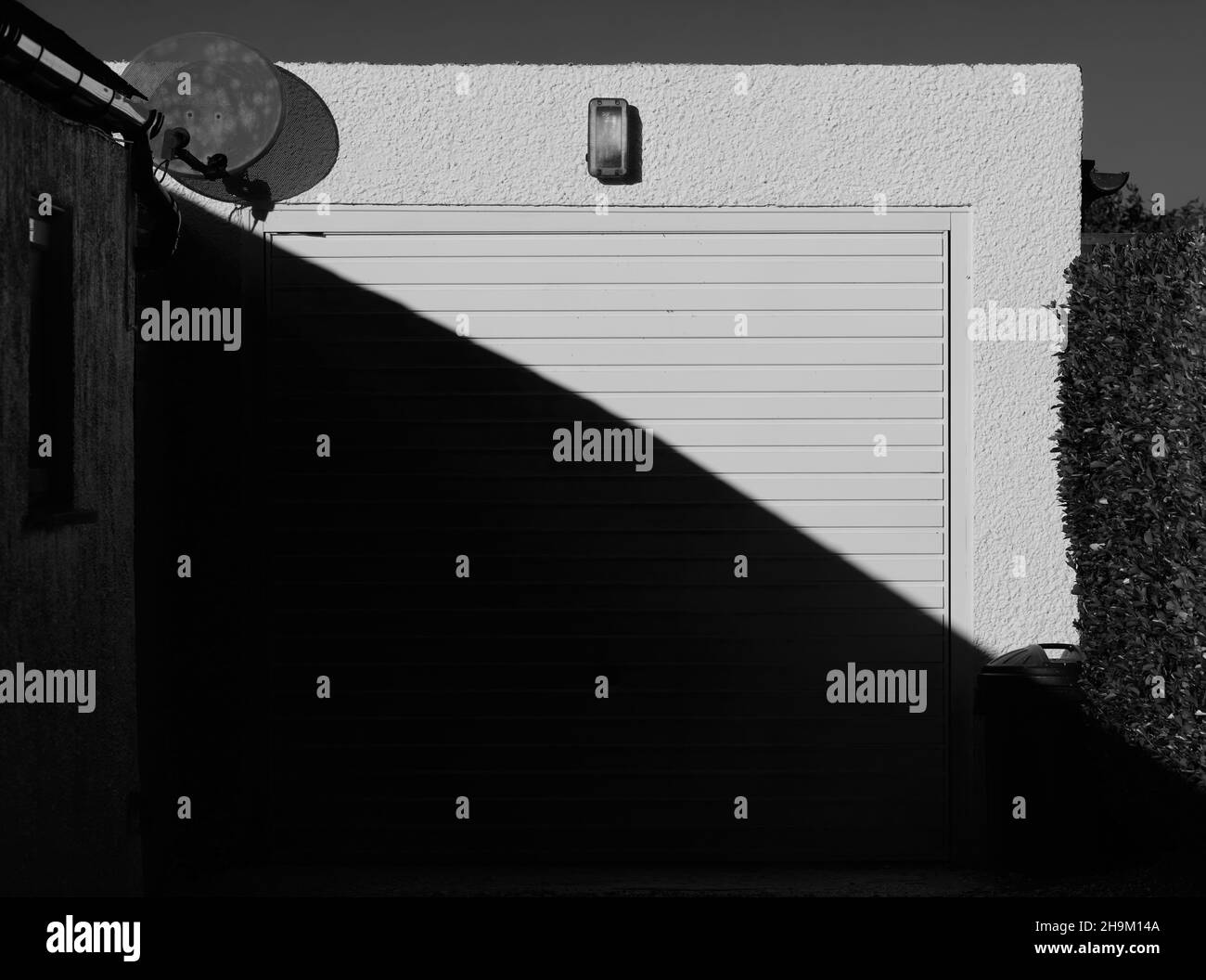 White garage door with half in the shade and half in sunlight Stock